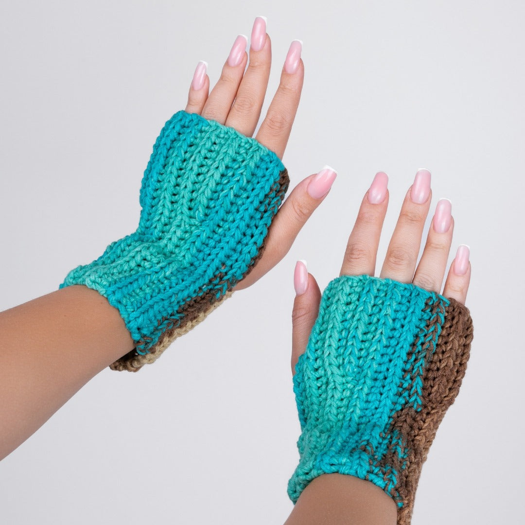 Turquoise and brown fingerless gloves worn on hands with a plain background
