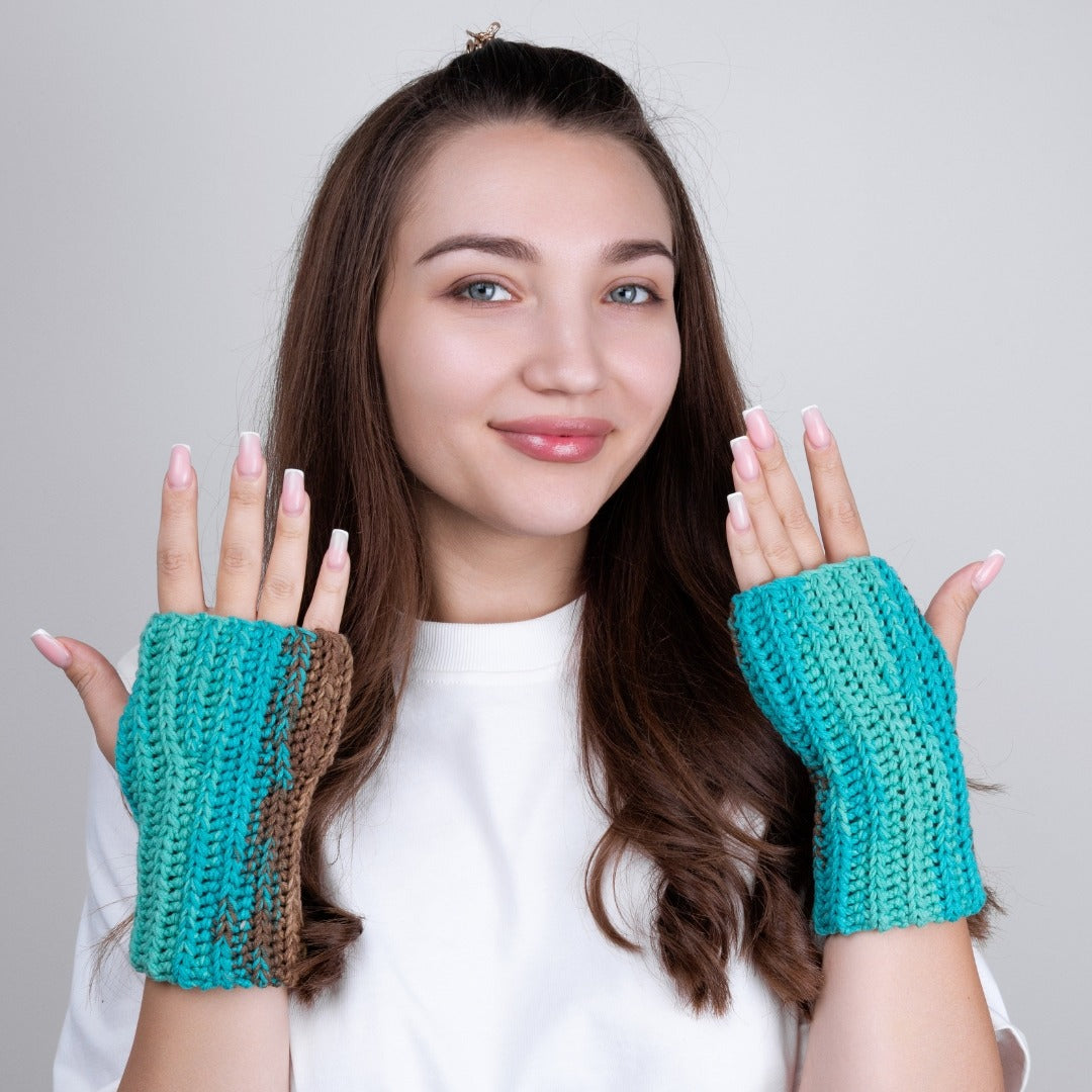Woman wearing teal fingerless gloves against a plain background
